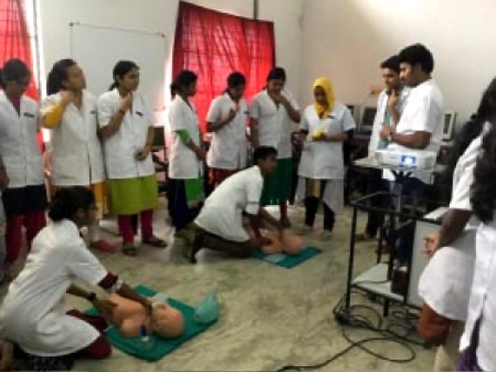 Nursing students practising chest compressions while classmates watch