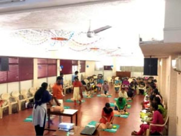 Hall full of participants practising CPR on manikins