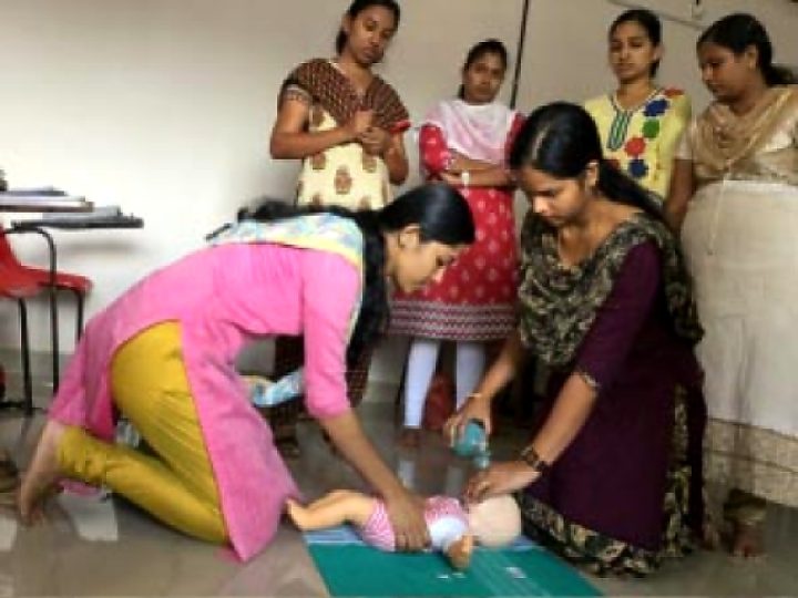 Participants practising infant CPR on a baby manikin